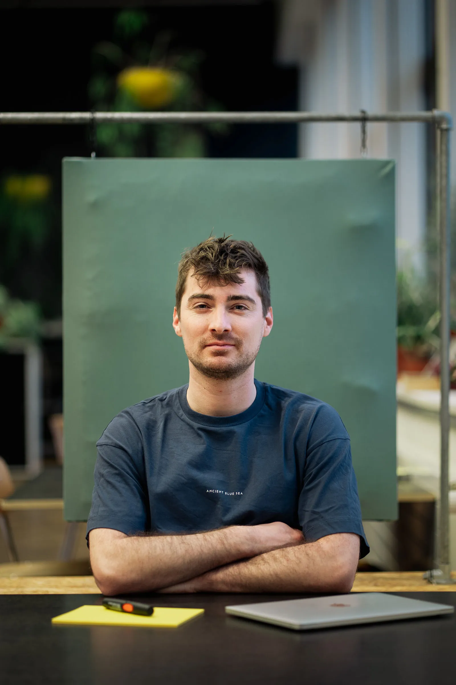 Juan mit verschränkten Armen am Tisch